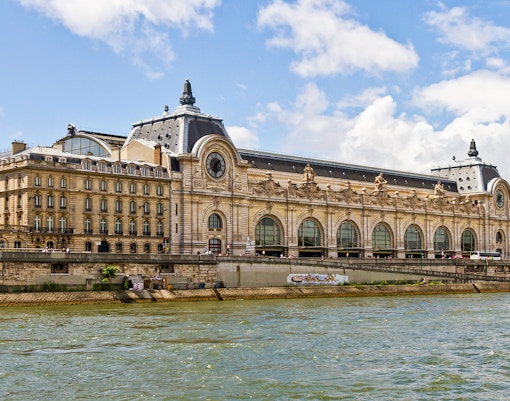 Tourists viewing paintings at Orsay Museum, Paris with fast-track tickets and temporary exhibition access.