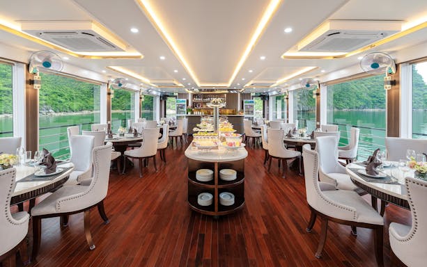 Buffet setup on a luxury cruise with scenic views of green hills and water at Hercules premium.