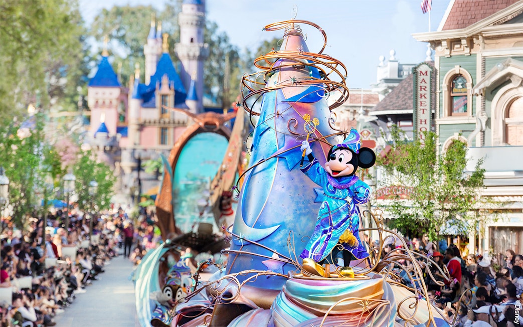 Mickey Mouse in a vibrant costume on a parade float at Disneyland Park, California.