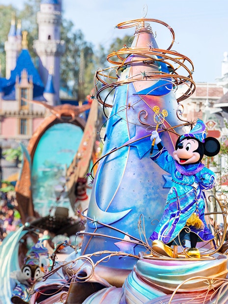 Mickey Mouse in a vibrant costume on a parade float at Disneyland Park, California.