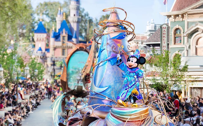 Mickey Mouse in a vibrant costume on a parade float at Disneyland Park, California.