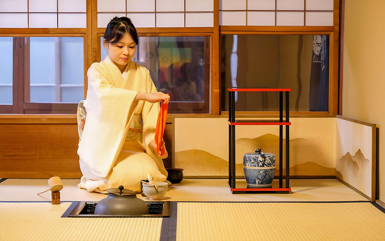 Japanese tea ceremony with sweets in traditional room setting.