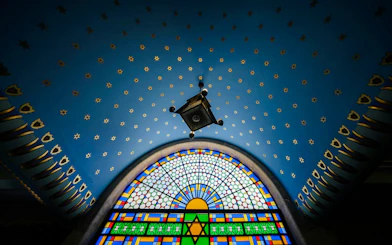 Stained glass window and starry ceiling inside Kazinczy Synagogue, Budapest.