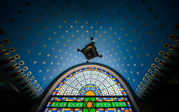 Stained glass window and starry ceiling inside Kazinczy Synagogue, Budapest.