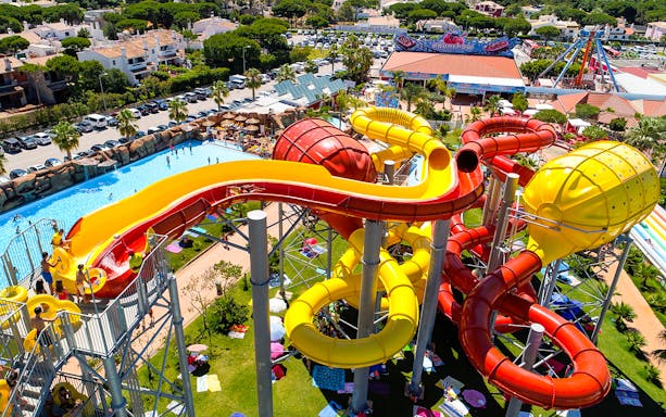 Colorful water slides at Aquashow Park, Portugal, with visitors enjoying the attractions.