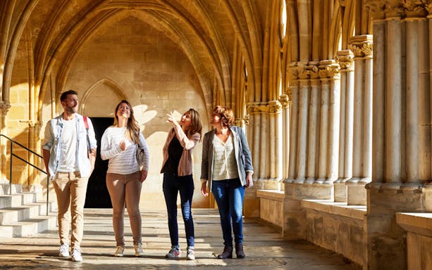 Group exploring historic cloister on French Basque Coast tour from San Sebastian.