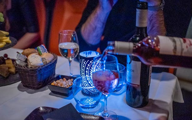 Wine being poured into a glass on the Happy Valentine Evening Cruise table setting.