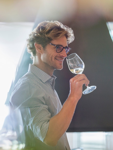 Friends enjoying a white wine tasting experience indoors.