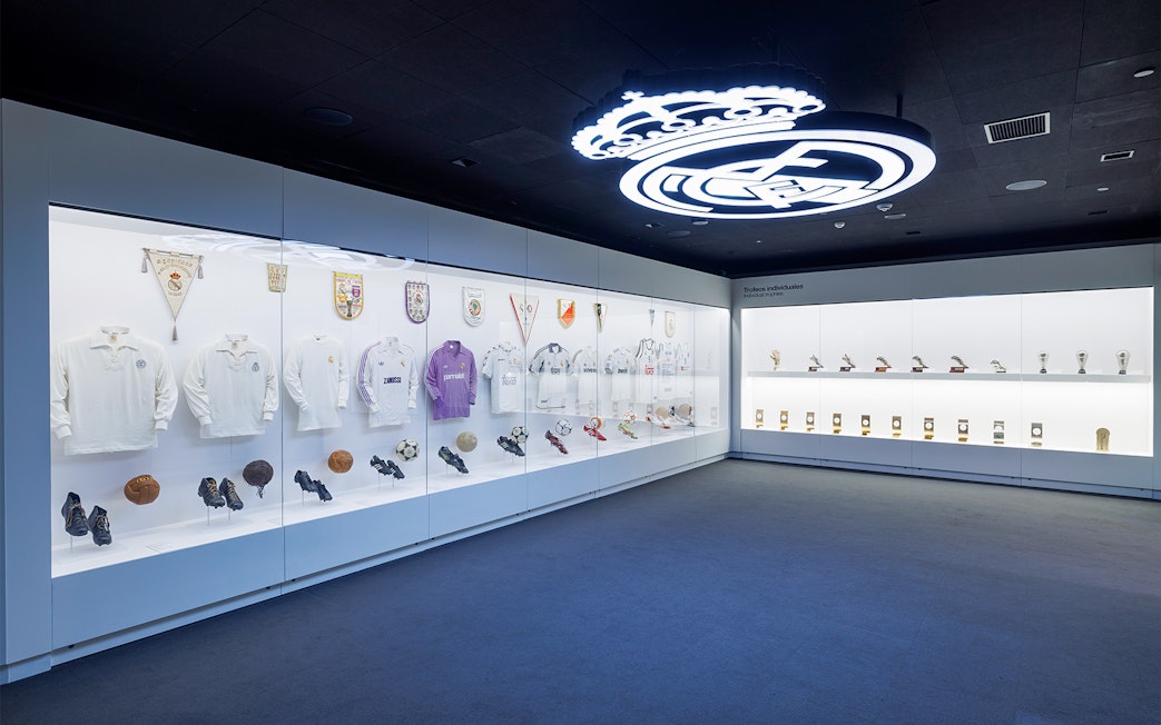 Santiago Bernabéu Stadium museum display with Real Madrid jerseys and trophies in Madrid, Spain.