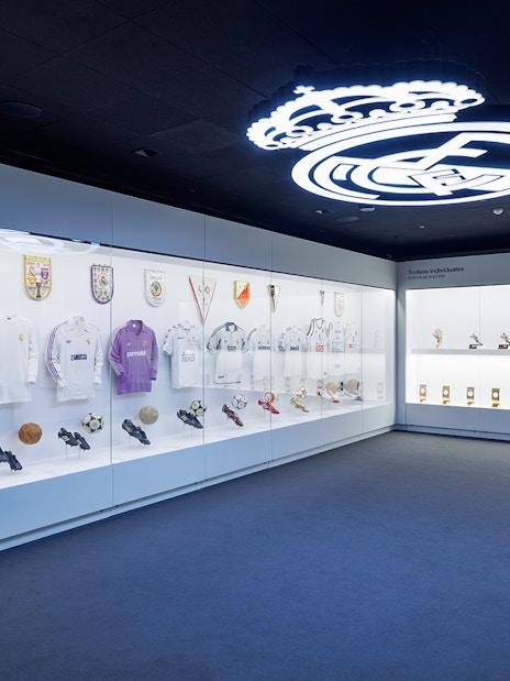 Santiago Bernabéu Stadium museum display with Real Madrid jerseys and trophies in Madrid, Spain.