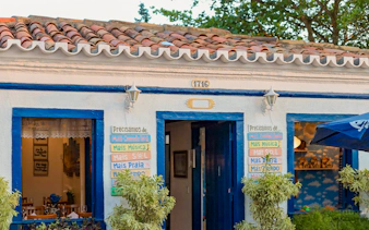 Historic building facade in Arraial do Cabo with colorful signs and blue accents.