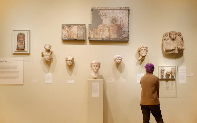 Woman viewing Roman artifacts at Seattle Art Museum.