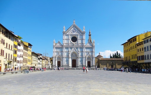 Basilica of Santa Croce in Florence with tourists in the square.