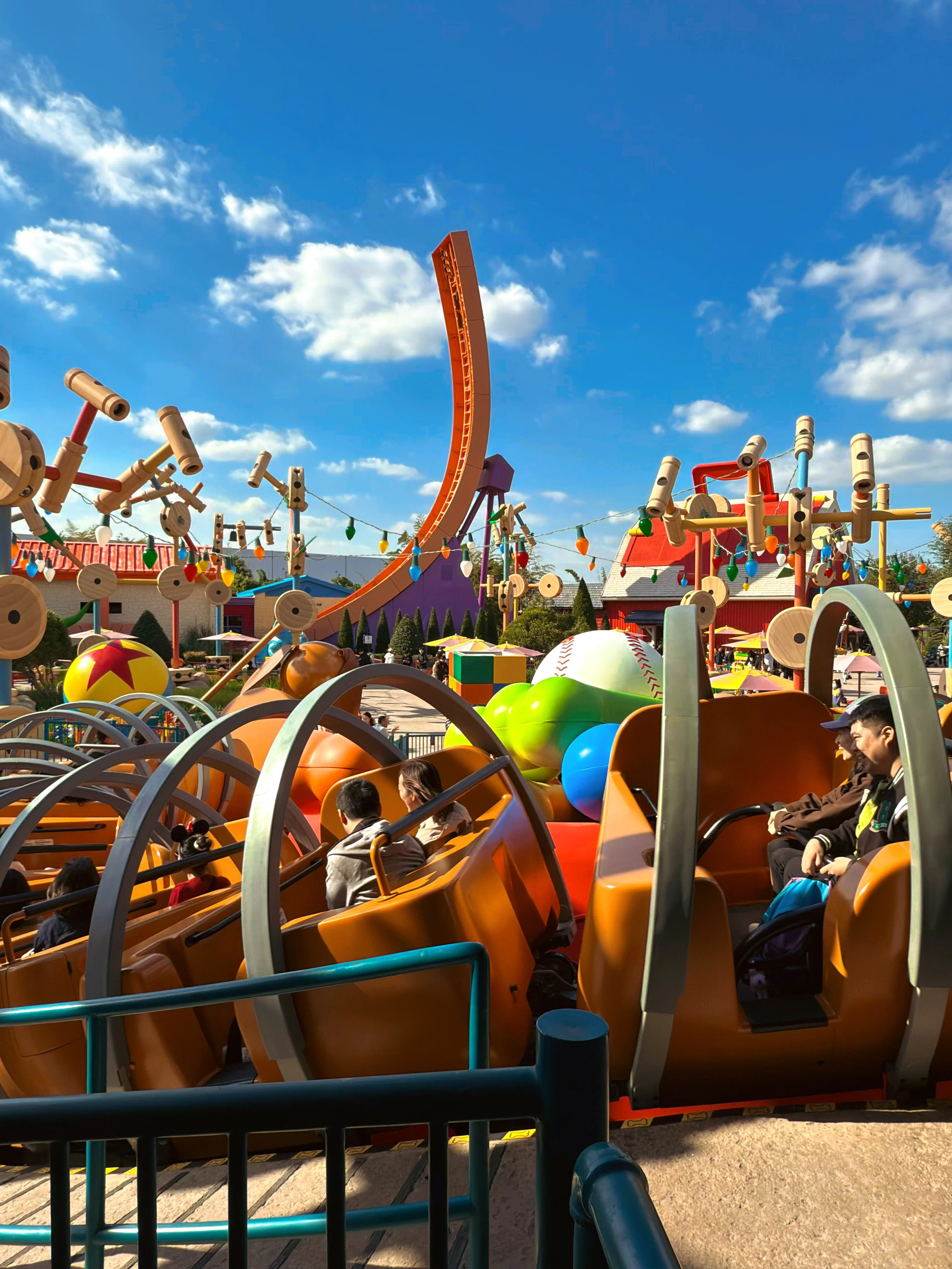 Shanghai Disneyland ride with colorful spinning cars and oversized toy decorations.