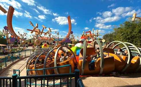 Shanghai Disneyland ride with colorful spinning cars and oversized toy decorations.