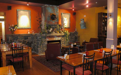 Riverhead Tavern interior with stone fireplace and dining tables set for guests.