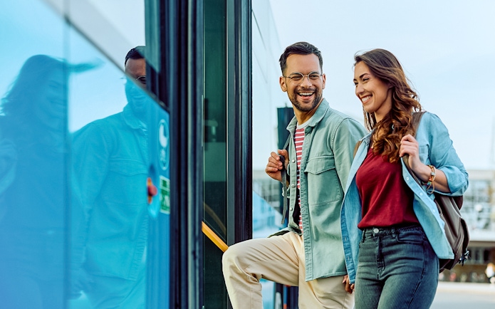 Passengers boarding a coach bus with smiles, ready for a tour.