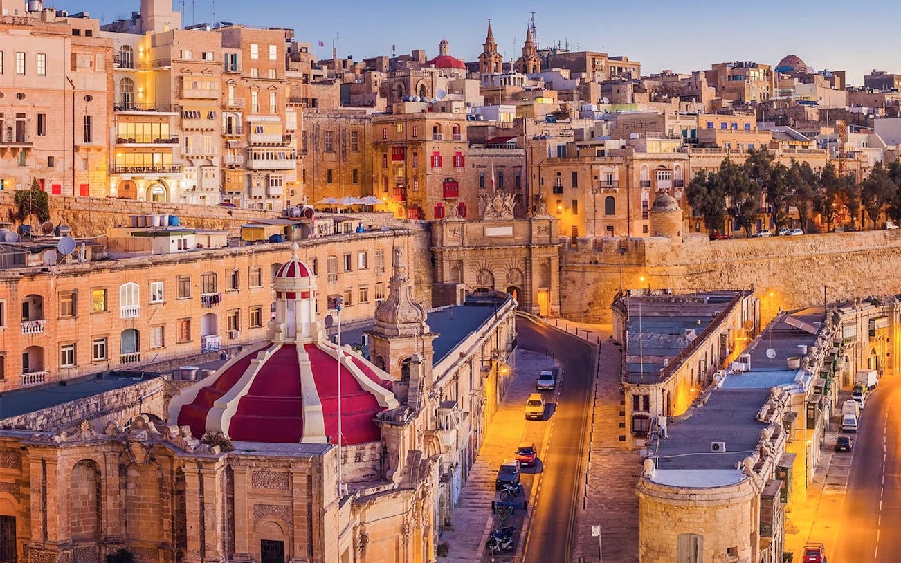 Historic buildings and streets of Valletta, Malta, illuminated at dusk during a guided night tour.