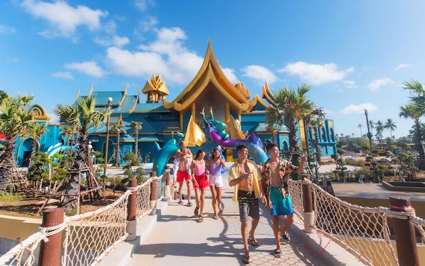 Guests walking at Andamanda water park entrance in Phuket, featuring vibrant architecture.