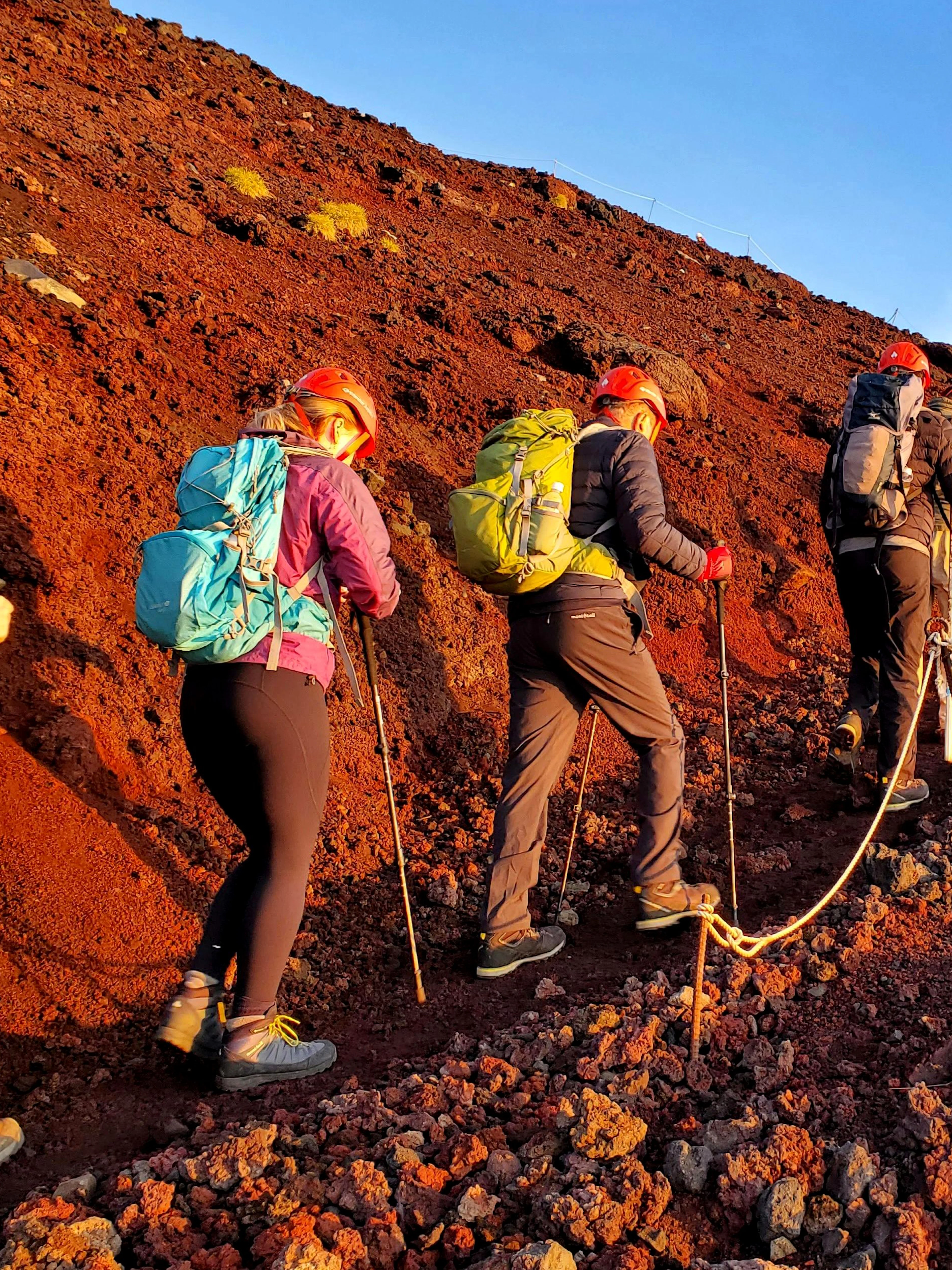 Climbers ascending rocky trail on Mt. Fuji during guided tour.