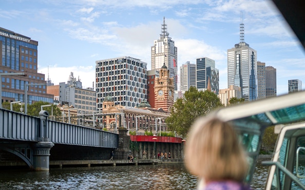 Guest viewing Melbourne skyline from a river cruise.