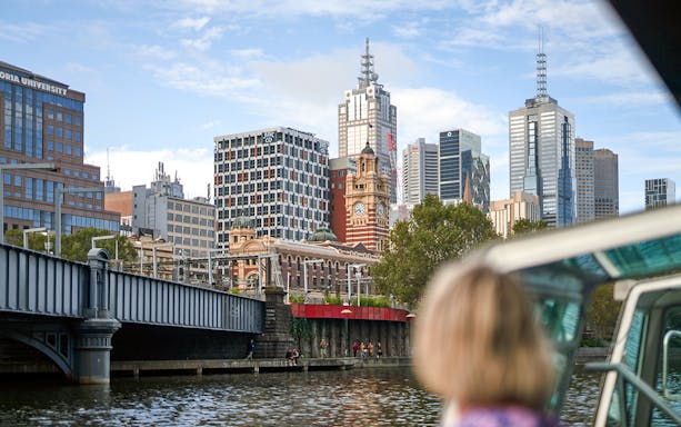 Guest viewing Melbourne skyline from a river cruise.