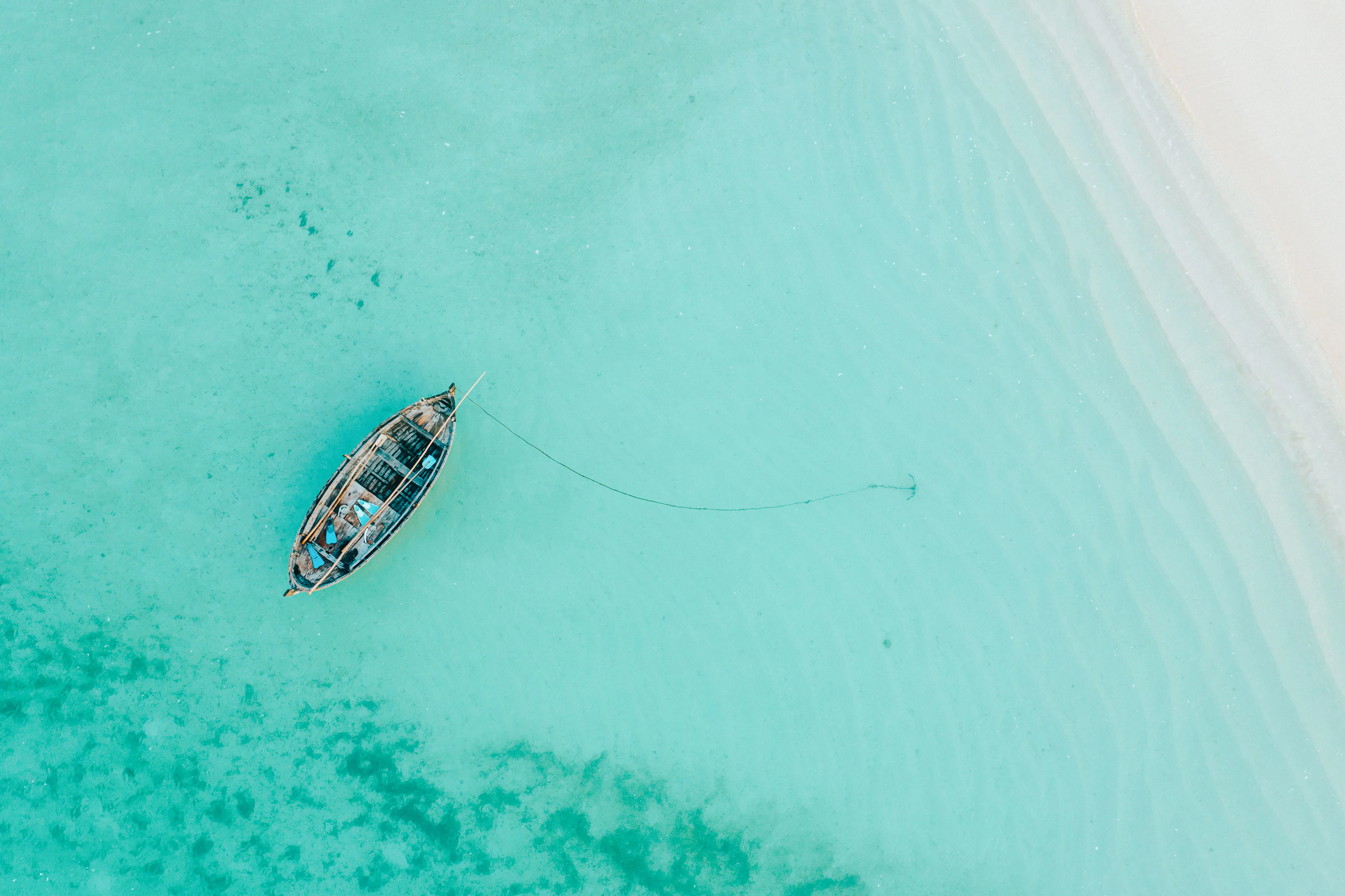 Traditional dhow anchored in turquoise waters of Mnemba Island, Zanzibar.