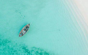 Traditional dhow anchored in turquoise waters of Mnemba Island, Zanzibar.