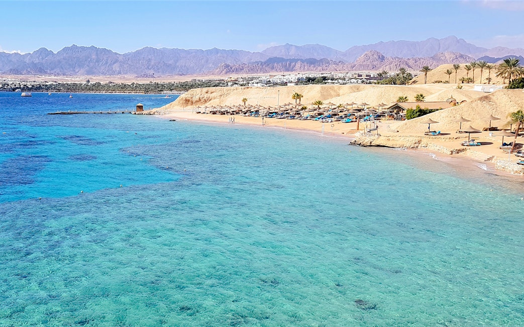 Magic Lake shoreline at Ras Muhammad National Park, Egypt, with clear blue waters and sandy beach.