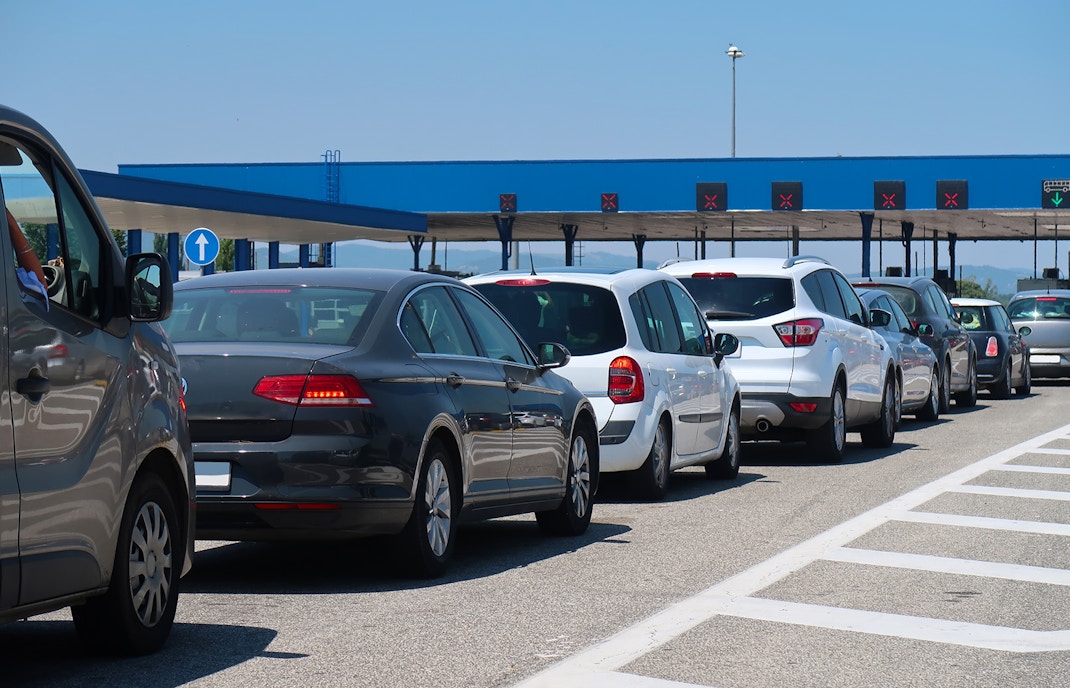 Border check post with travelers and vehicles in line, enhancing border crossing experience.