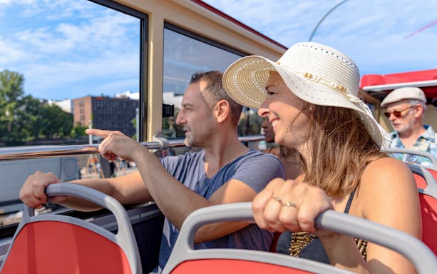 People enjoying a Hop-On Hop-Off bus tour in Berlin, viewing city landmarks.
