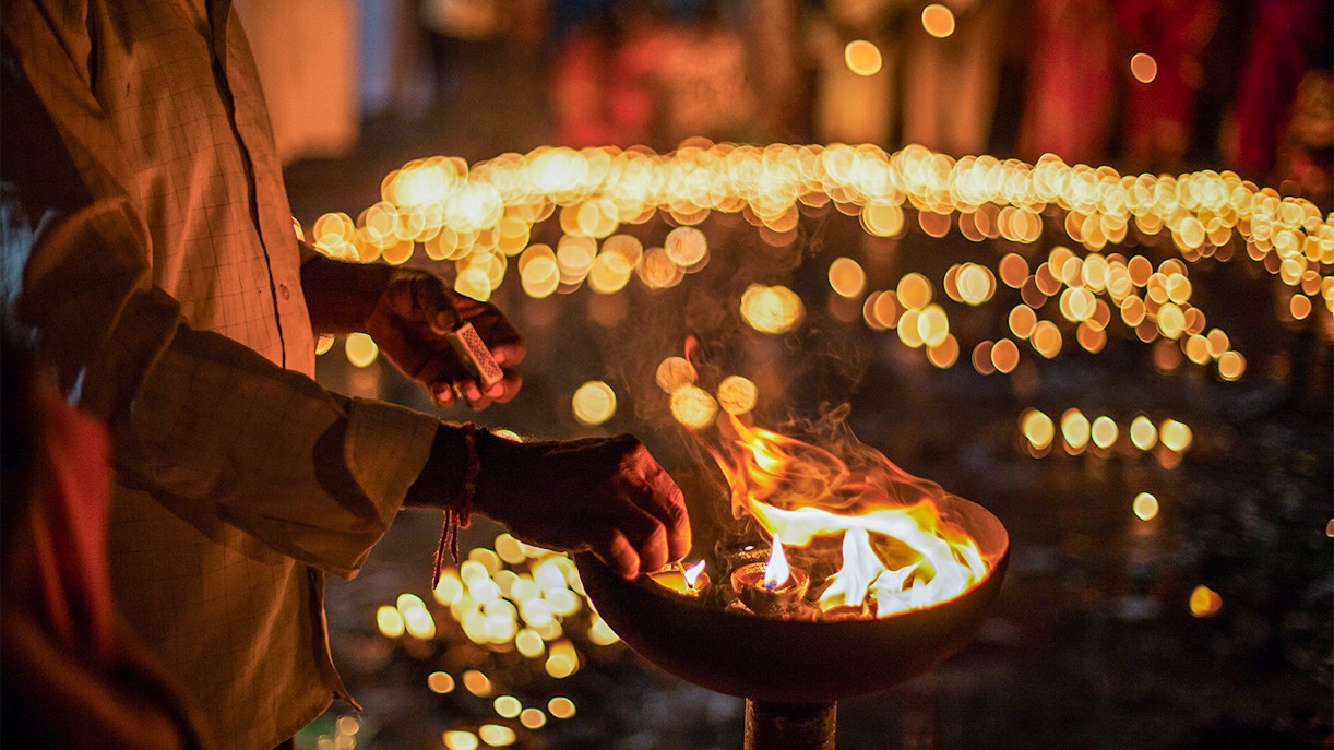 People celebrating Diwali with fireworks in a city square, highlighting global festivities.