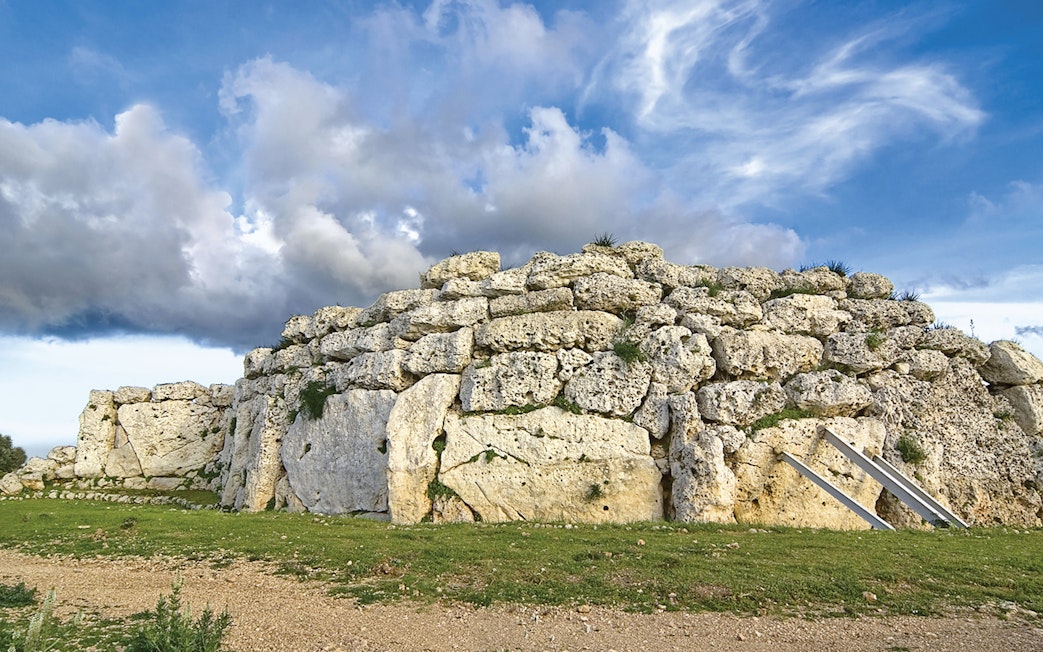 Ancient stone structure at Ġgantija Temples, Gozo, under a cloudy sky.