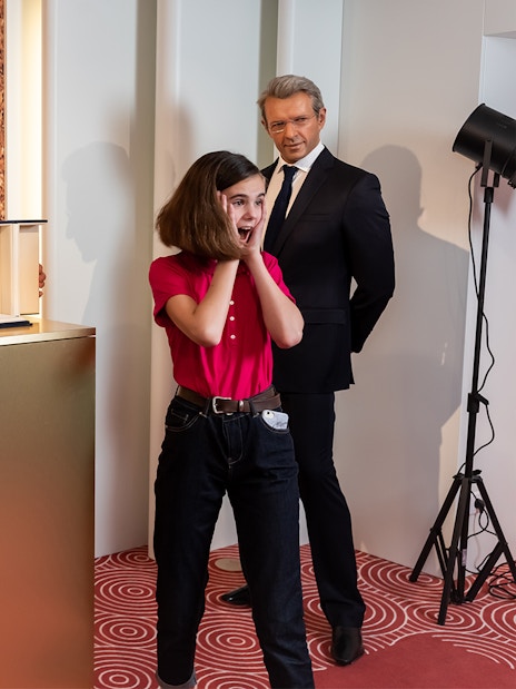 Grévin Wax Museum visitors admire wax figures and a Palme d'Or trophy display.