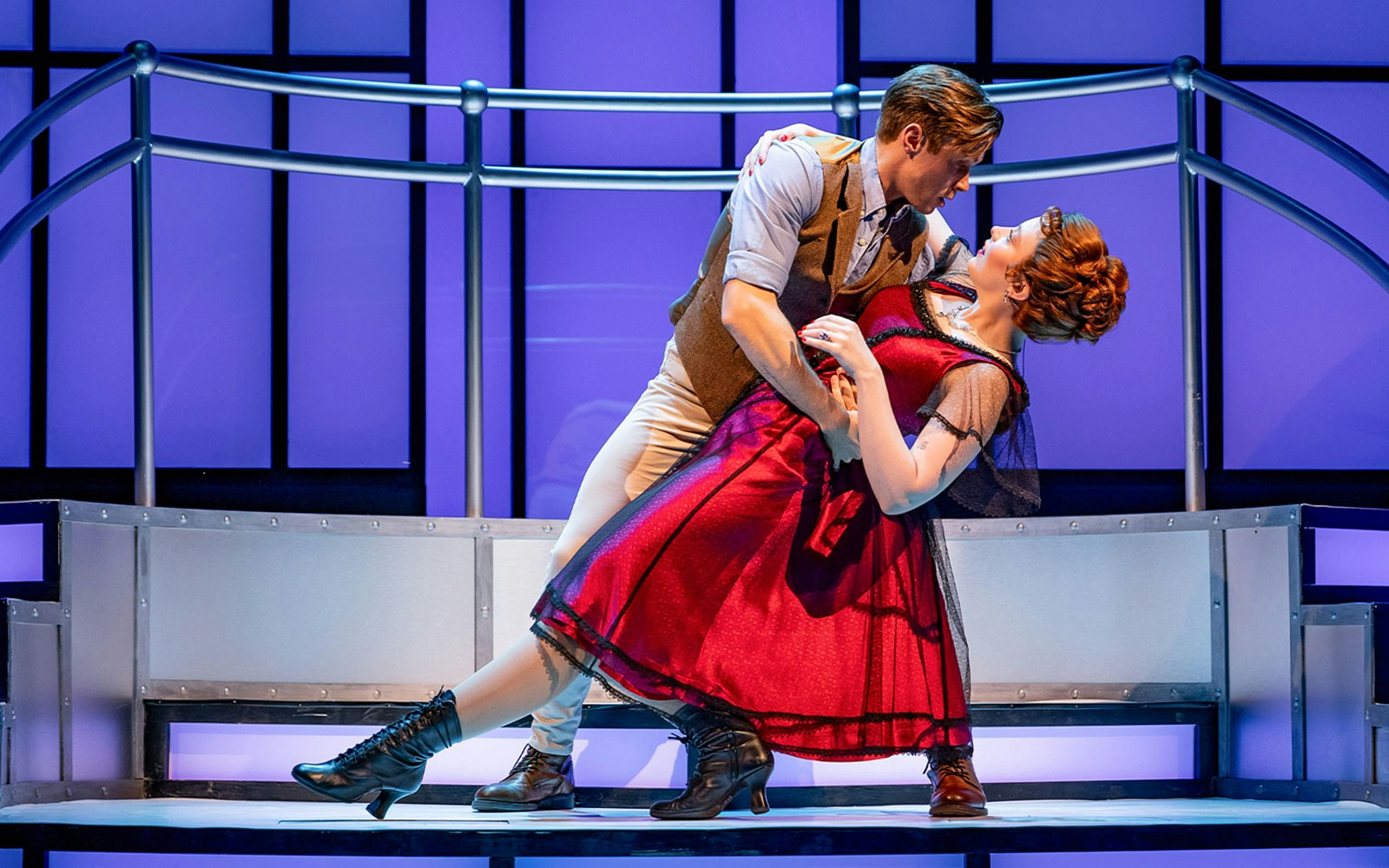 Couple dancing on a ship set in the Titanique musical.