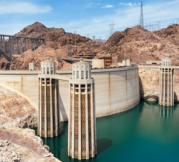 Hoover Dam with turquoise Lake Mead and surrounding rocky landscape near Las Vegas, Nevada.