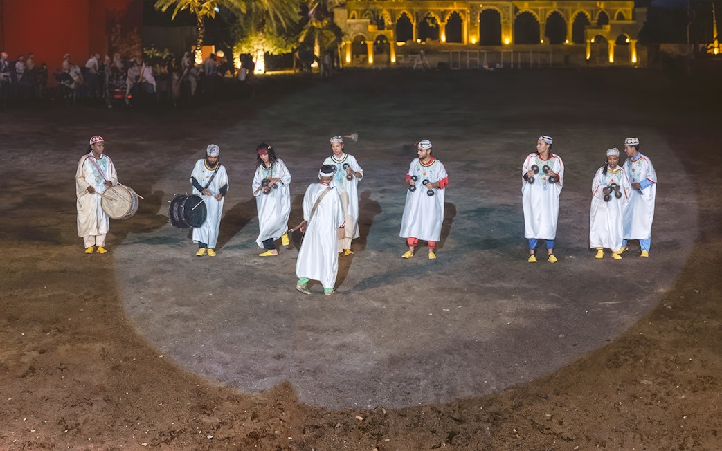 Performers in traditional attire playing instruments at Chez Ali Dinner & Fantasia Show, Morocco.