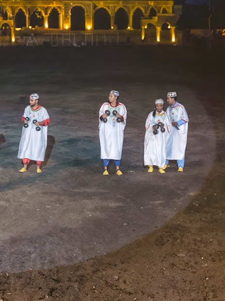 Performers in traditional attire playing instruments at Chez Ali Dinner & Fantasia Show, Morocco.