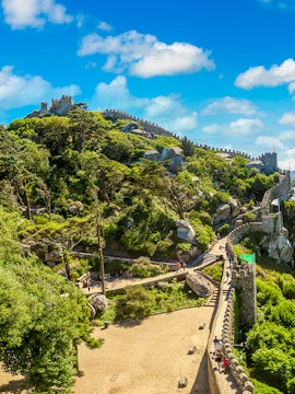 Moorish Castle in Lisbon with stone walls and lush greenery.
