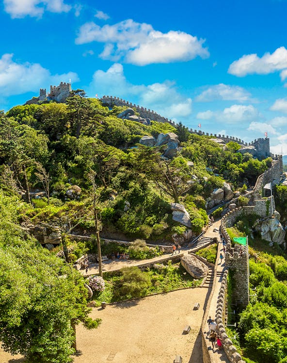 Moorish Castle in Lisbon with stone walls and lush greenery.