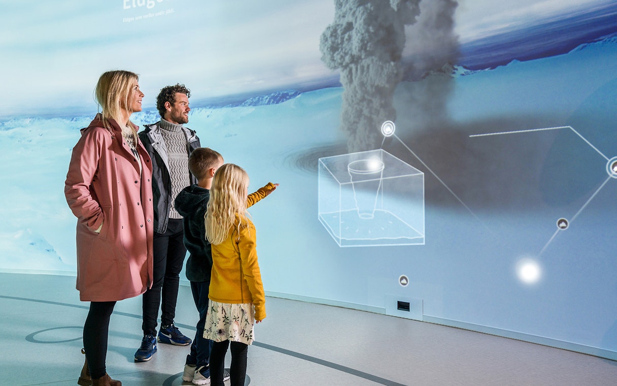 Family exploring interactive exhibit at Perlan's Wonders of Iceland.