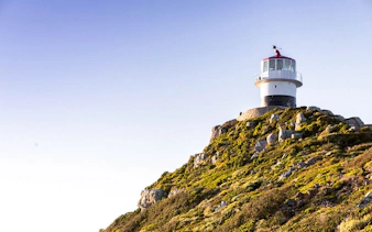 Lighthouse on rocky hill at Cape of Good Hope, Cape Town.