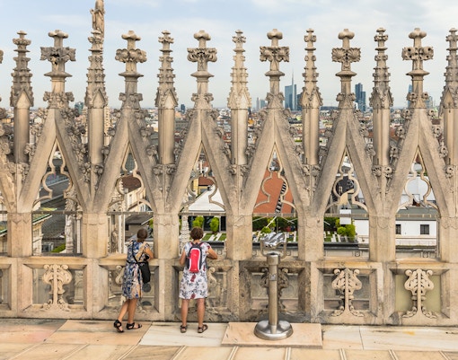 Duomo Milan Cathedral facade with tourists on Fast-Track guided tour, Italy.