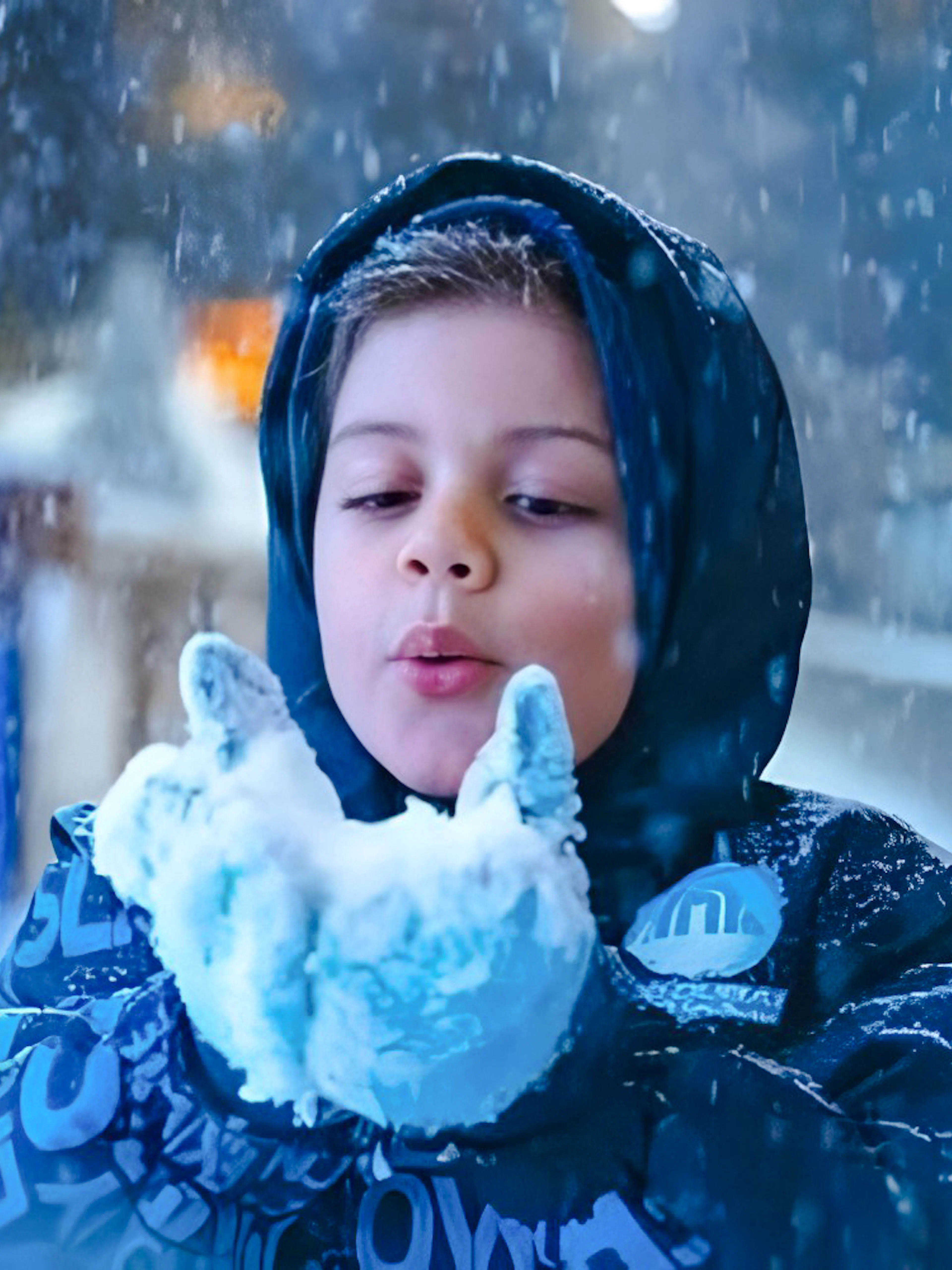 Child enjoying snow at indoor Snow Abu Dhabi park, Abu Dhabi.