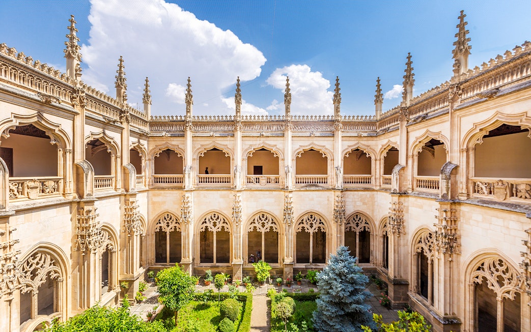 Cloister of San Juan de los Reyes in Toledo, Spain, with Gothic architecture and garden.