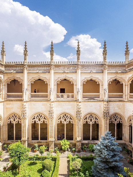 Cloister of San Juan de los Reyes in Toledo, Spain, with Gothic architecture and garden.