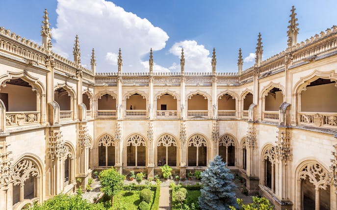 Cloister of San Juan de los Reyes in Toledo, Spain, with Gothic architecture and garden.