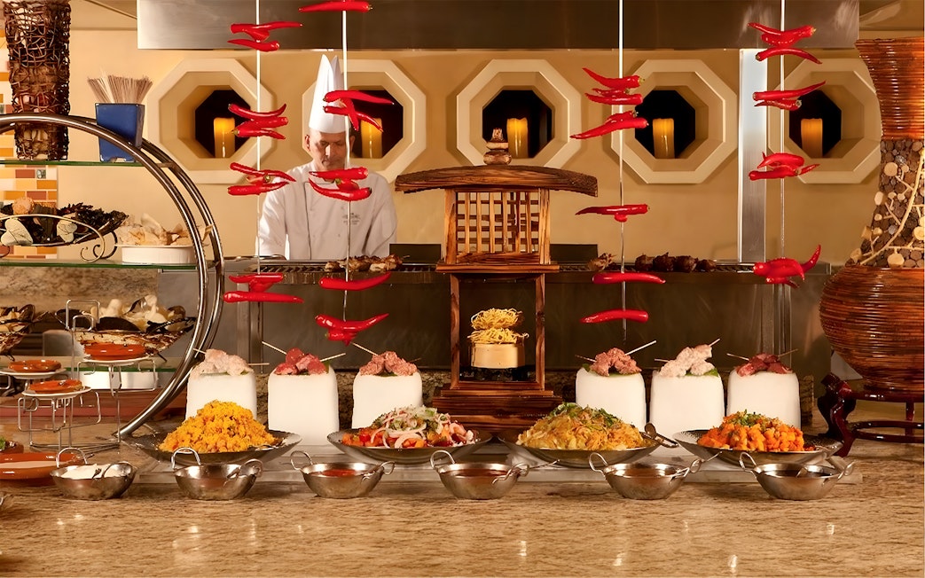 Live kitchen display at Buffet Kaleidoscope Atlantis Dubai with chef and diverse dishes.