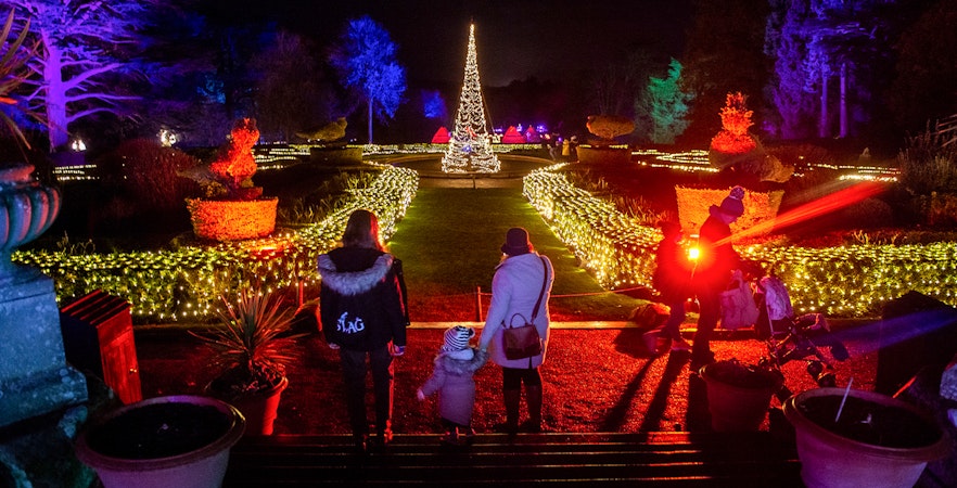 Guests walking through illuminated gardens at Warwick Castle Light Trail.