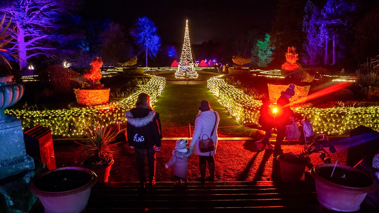 Guests walking through illuminated gardens at Warwick Castle Light Trail.